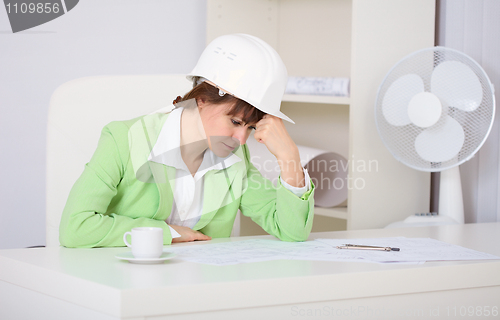 Image of Tired woman engineer in workplace