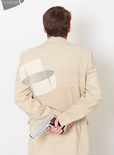 Image of Person hides behind back weapon - rear view