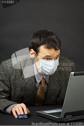 Image of Surprised businessman in medical mask works in Internet