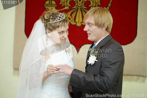 Image of Young bride solemnly ringed groom