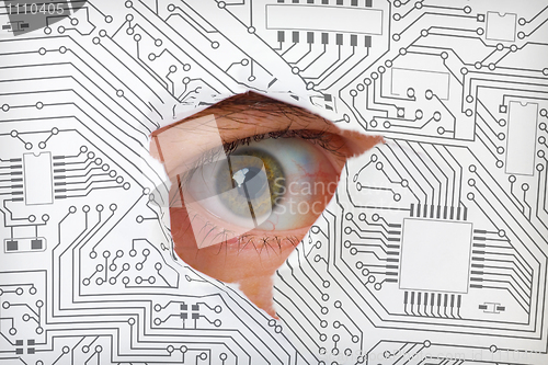 Image of Eye looking through a hole in electronic circuit