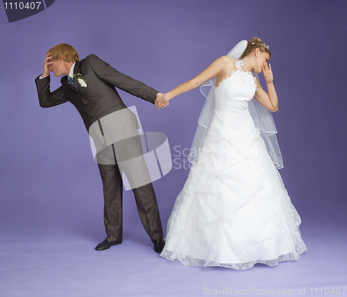 Image of Comical emotional groom and bride holding hands
