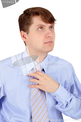Image of Man adjusts blue tie isolated on white