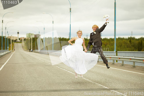 Image of Newly married pair jumps on highway