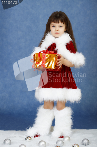 Image of Little girl in fur New Year's clothes with gift