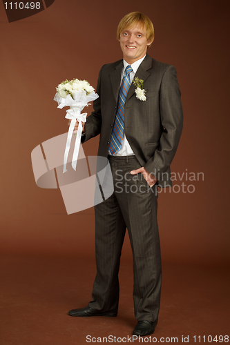 Image of Happy groom with bouquet