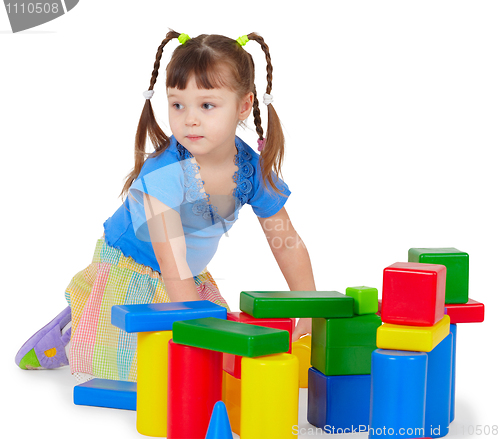 Image of Little girl is playing with color bricks