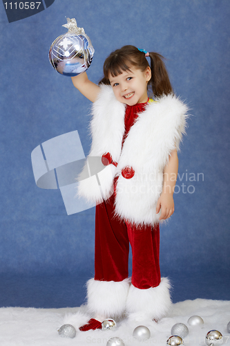 Image of Little girl in New Year costume holding glass ball