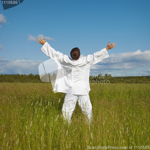 Image of Man enjoys nature and fresh air in a field