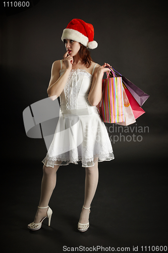 Image of Woman in New Year's clothes thinks of purchase