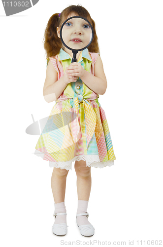 Image of Little girl looks at you through large magnifying glass