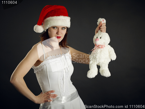 Image of Young woman in Christmas cap holds a rabbit