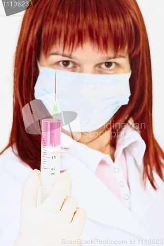 Image of Young woman doctor with syringe in hand