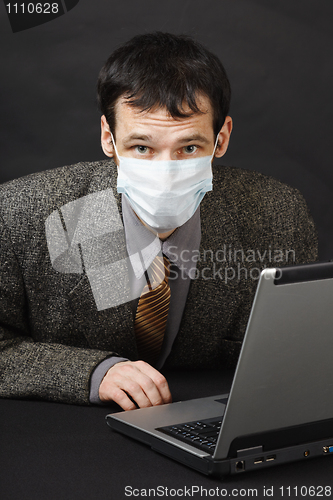Image of Man in medical mask works in Internet
