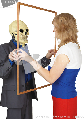 Image of Woman looks at skeleton as reflected