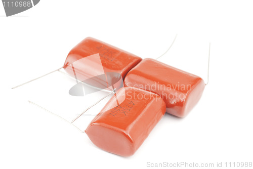 Image of Three orange  capacitor  isolated on white background