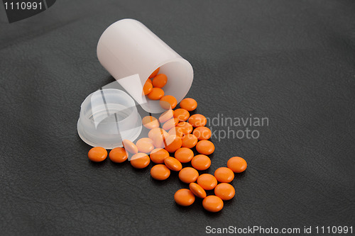 Image of orange pill  black background