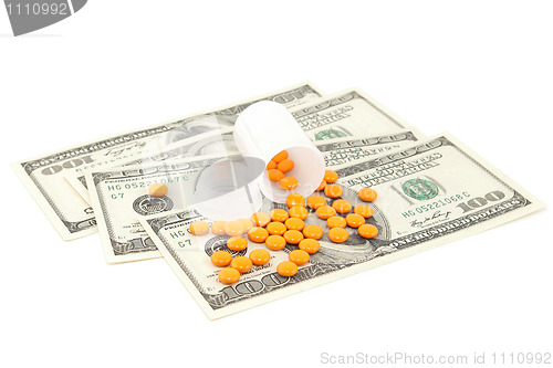 Image of orange pill at the money , isolated on white background