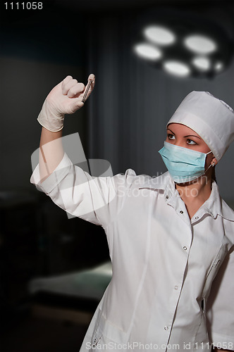 Image of young pretty surgeon holding nail for osteosynthesis