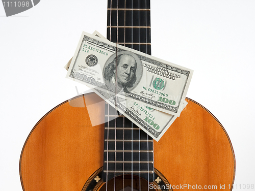 Image of Classical guitar and money