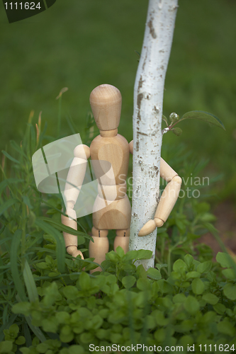 Image of Wooden toy man hugging tree