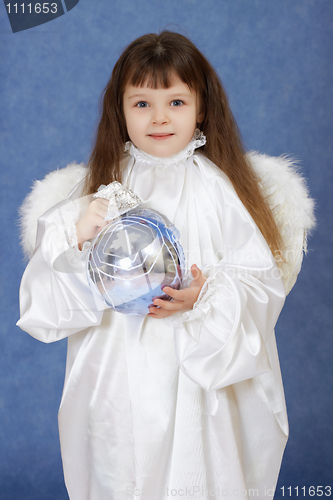 Image of Child dressed as an angel with wings holding glass ball