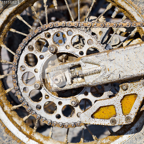 Image of Rear wheel of motorcycle with chain covered with dirt