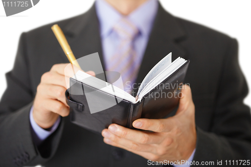 Image of Businessman takes notes in notebook - closeup