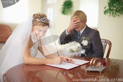 Image of Marriage registration. Bride is happy. Groom in grief.