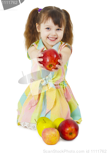 Image of Happily smiling little girl gives an apple