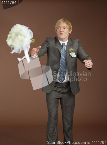 Image of Groom catches a flying bouquet