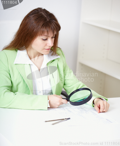 Image of Beautiful girl works with drawing by means of magnifier