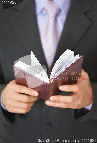 Image of Businessman checks schedule of day in organizer