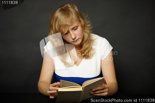 Image of Woman reading book at night