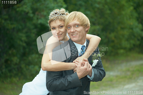 Image of Smiling happy bride embraces groom