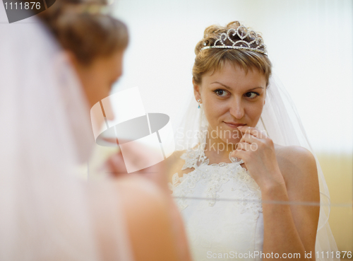 Image of Bride admires himself in mirror