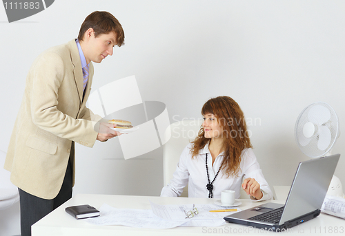 Image of Businessman treats hamburger colleague