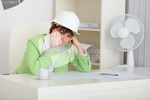 Image of Thoughtful woman - builder in helmet