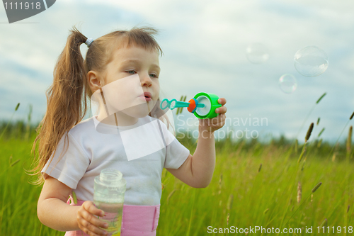 Image of Little girl starts soap bubbles
