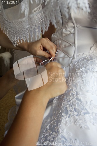 Image of To the bride fasten a wedding dress