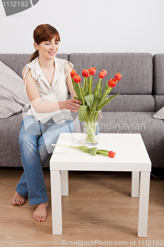 Image of Woman at home holding flowers