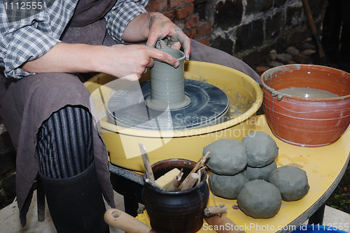 Image of potter's wheel and hands of craftsman