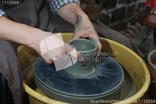 Image of potter's wheel and hands of craftsman