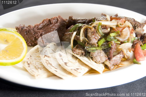 Image of beef stir fry with mashed beans and tamales Nicaragua