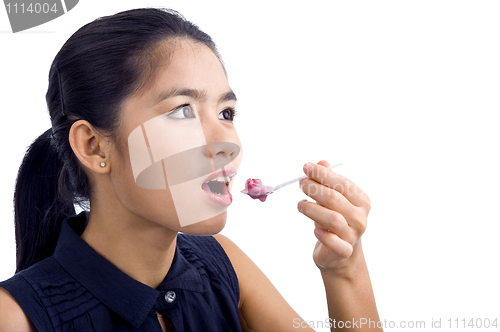 Image of young beautiful woman eating yogurt