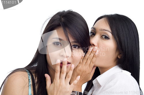 Image of woman telling her friend a secret