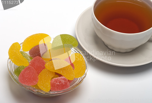 Image of Cup of tea and fruit candy.