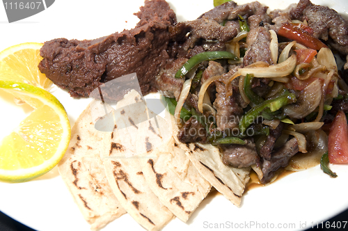 Image of beef stir fry with mashed beans and tamales Nicaragua