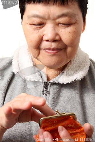 Image of senior chinese woman taking money from bag