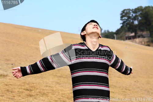 Image of Carefree man standing in golden grass field being happy enjoying